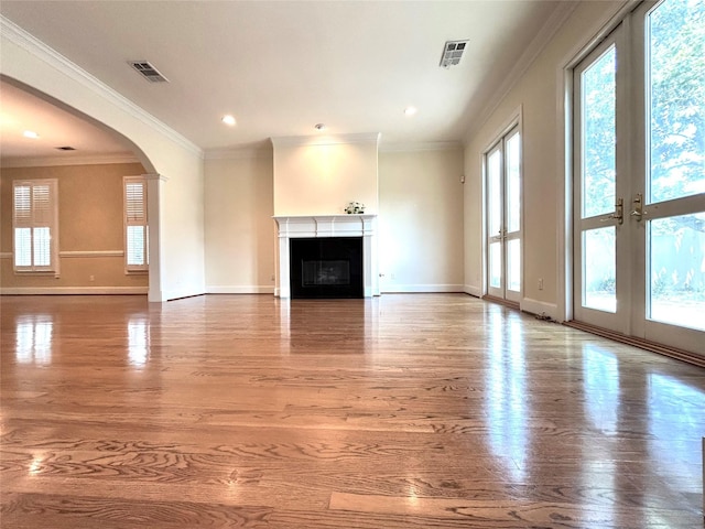 6021 Valley Forge Dr, Houston, TX 77057 - unfurnished living room featuring wood finished floors, baseboards, arched walkways, crown molding, and a fireplace