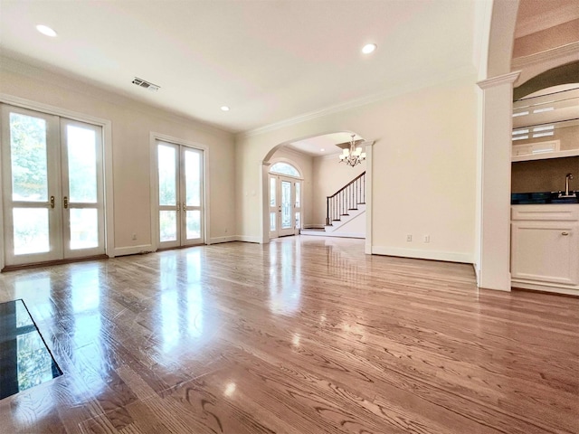 6021 Valley Forge Dr, Houston, TX 77057 - unfurnished living room with french doors, arched walkways, crown molding, baseboards, and wood finished floors