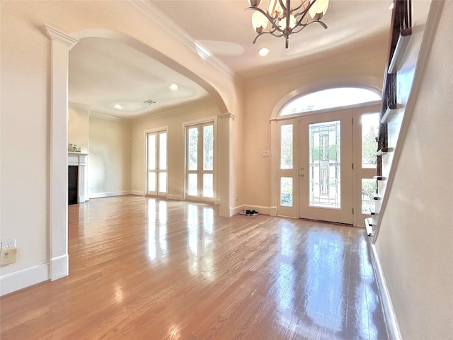 6021 Valley Forge Dr, Houston, TX 77057 - foyer entrance with arched walkways, crown molding, a chandelier, wood finished floors, and baseboards