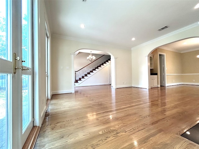 6021 Valley Forge Dr, Houston, TX 77057 - unfurnished room featuring arched walkways, baseboards, wood finished floors, a chandelier, and crown molding