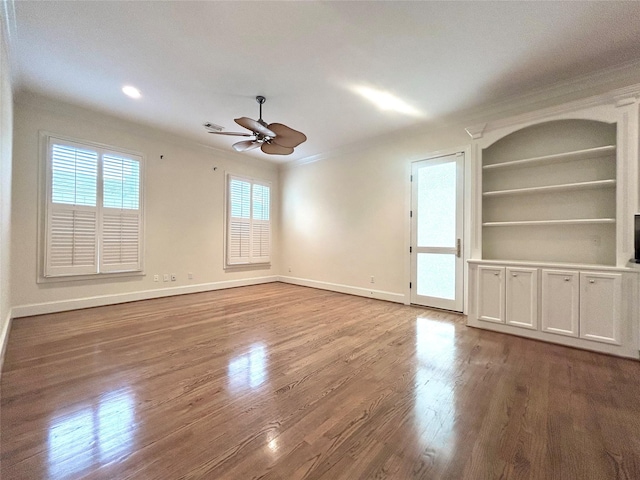 6021 Valley Forge Dr, Houston, TX 77057 - spare room featuring crown molding, a ceiling fan, wood finished floors, baseboards, and built in shelves