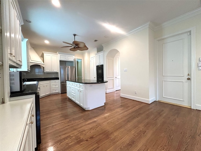 6021 Valley Forge Dr, Houston, TX 77057 - kitchen with freestanding refrigerator, a ceiling fan, arched walkways, crown molding, and dark countertops