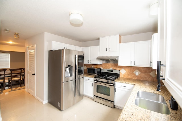 7707 Kempsey Ln, Houston, TX 77040 - kitchen with appliances with stainless steel finishes, under cabinet range hood, tasteful backsplash, white cabinets, and baseboards