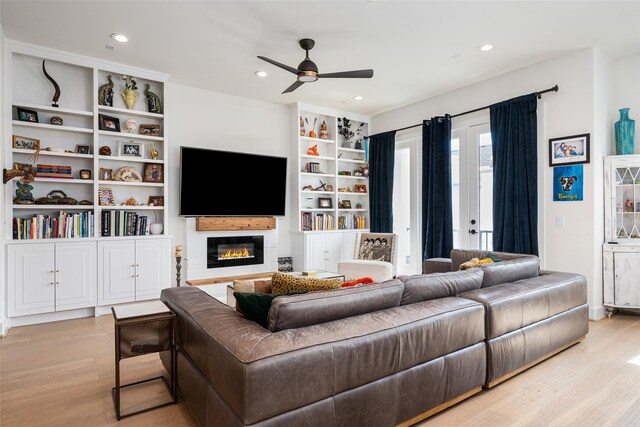 1747 Ojeman Spring Ln, Houston, TX 77055 - living room with light wood finished floors, a ceiling fan, a glass covered fireplace, and recessed lighting