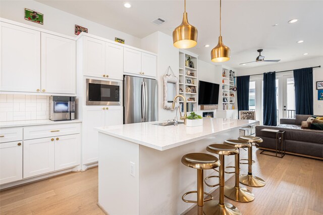 1747 Ojeman Spring Ln, Houston, TX 77055 - kitchen with appliances with stainless steel finishes, open floor plan, light wood-style floors, recessed lighting, and white cabinets