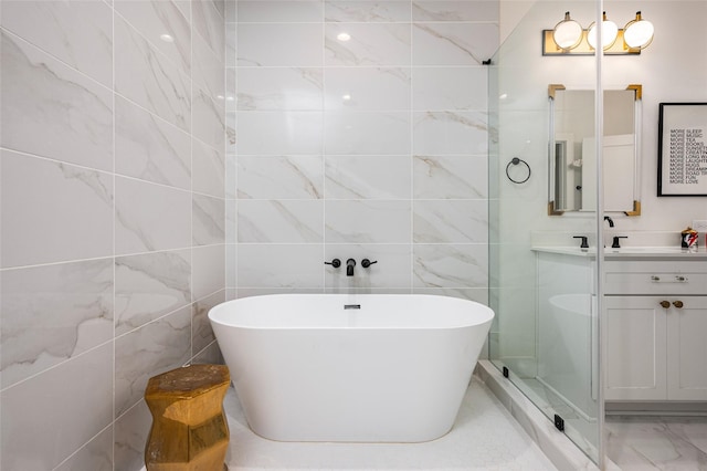 1747 Ojeman Spring Ln, Houston, TX 77055 - full bathroom featuring double vanity, a soaking tub, marble finish flooring, and tile walls