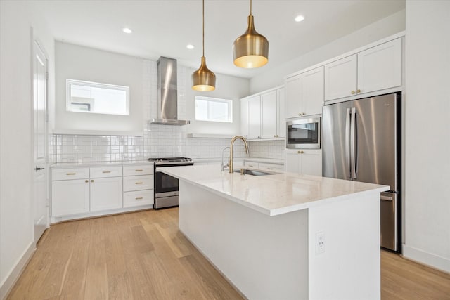 1747 Ojeman Spring Ln, Houston, TX 77055 - kitchen with stainless steel appliances, wall chimney range hood, light wood finished floors, plenty of natural light, and recessed lighting