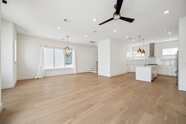1747 Ojeman Spring Ln, Houston, TX 77055 - unfurnished living room with ceiling fan, light wood finished floors, stairway, recessed lighting, and a chandelier