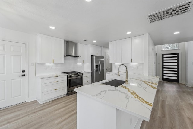 16739 Innisbrook Dr, Houston, TX 77095 - kitchen with wall chimney exhaust hood, appliances with stainless steel finishes, a sink, light wood finished floors, and recessed lighting