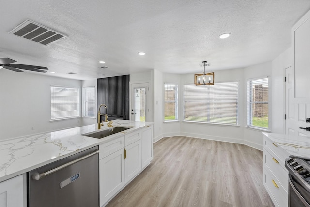 16739 Innisbrook Dr, Houston, TX 77095 - kitchen featuring a sink, appliances with stainless steel finishes, a textured ceiling, white cabinetry, and light wood-style floors