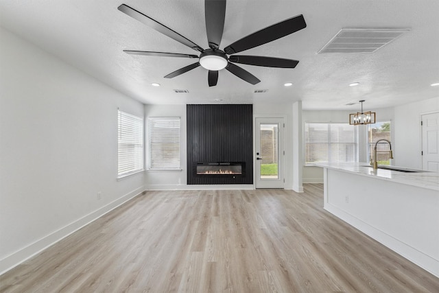 16739 Innisbrook Dr, Houston, TX 77095 - unfurnished living room with a textured ceiling, light wood-type flooring, a sink, baseboards, and recessed lighting