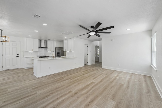 16739 Innisbrook Dr, Houston, TX 77095 - unfurnished living room with light wood finished floors, recessed lighting, arched walkways, a ceiling fan, and baseboards