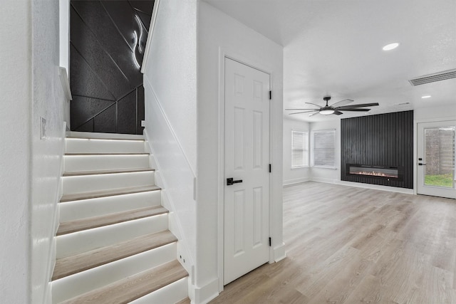 16739 Innisbrook Dr, Houston, TX 77095 - stairway with wood finished floors, a ceiling fan, a glass covered fireplace, recessed lighting, and baseboards