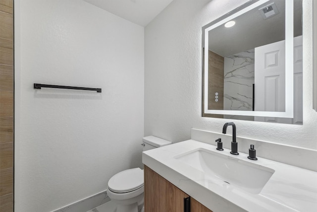16739 Innisbrook Dr, Houston, TX 77095 - full bathroom featuring a textured wall, vanity, toilet, marble finish flooring, and baseboards