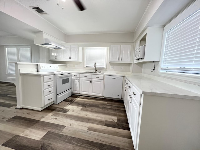 307 Veselka Road Cr, Freeport, TX 77541 - kitchen with white appliances, ventilation hood, a sink, a peninsula, and white cabinets