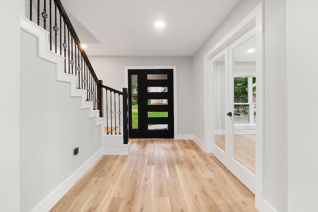 9 Indian Cedar Ln, The Woodlands, TX 77380 - foyer entrance featuring light wood finished floors, baseboards, and stairs