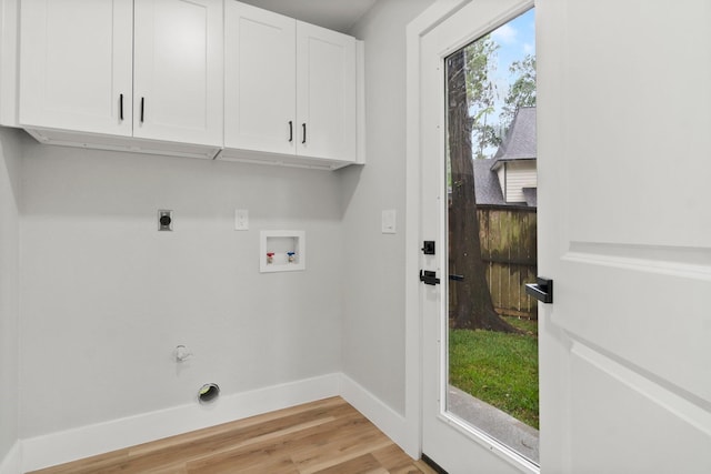 9 Indian Cedar Ln, The Woodlands, TX 77380 - washroom featuring hookup for an electric dryer, cabinet space, hookup for a washing machine, baseboards, and light wood finished floors