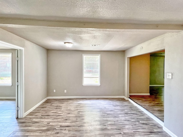 5813 Mayle St, Houston, TX 77016 - empty room featuring healthy amount of natural light, wood finished floors, a textured ceiling, and baseboards