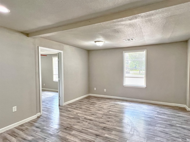 5813 Mayle St, Houston, TX 77016 - empty room featuring wood finished floors, baseboards, and a textured ceiling