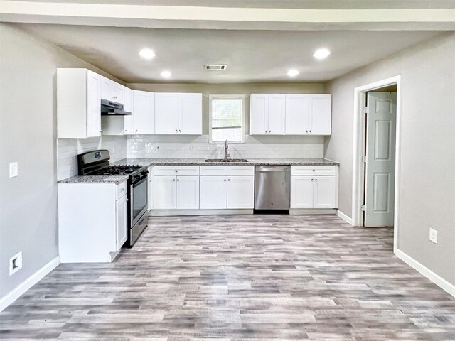 5813 Mayle St, Houston, TX 77016 - kitchen with appliances with stainless steel finishes, a sink, baseboards, white cabinetry, and recessed lighting