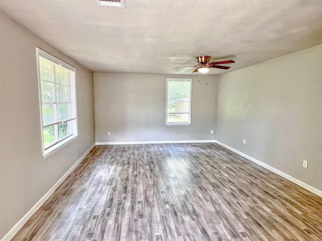5813 Mayle St, Houston, TX 77016 - spare room featuring baseboards, wood finished floors, ceiling fan, and a textured ceiling
