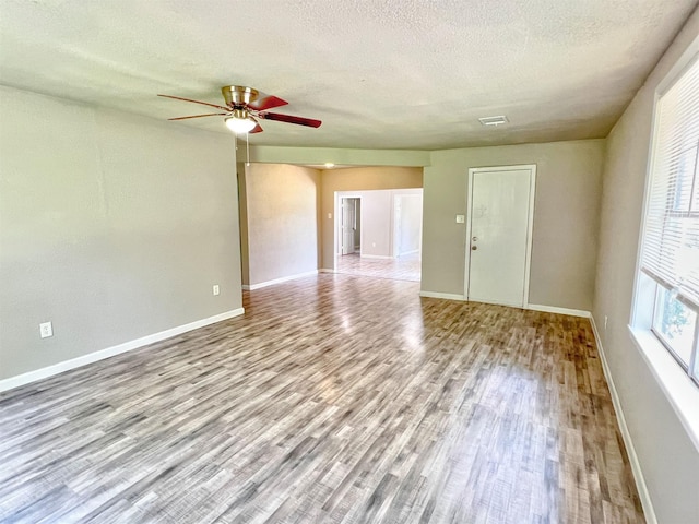 5813 Mayle St, Houston, TX 77016 - spare room featuring wood finished floors, a ceiling fan, baseboards, and a textured ceiling