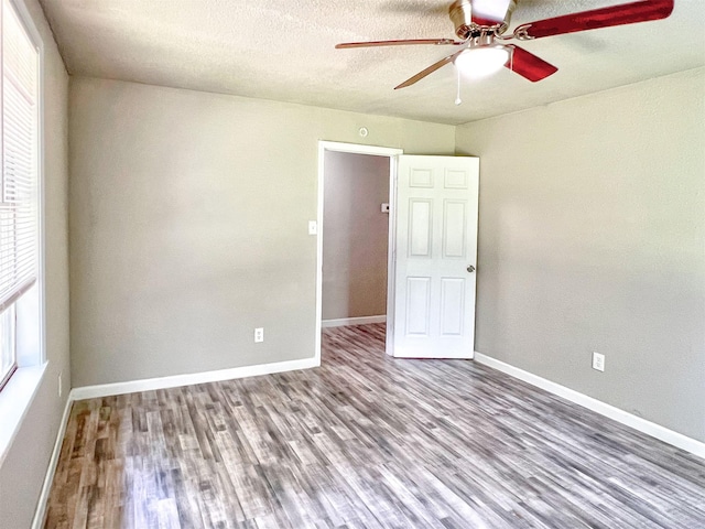 5813 Mayle St, Houston, TX 77016 - unfurnished room featuring healthy amount of natural light, wood finished floors, a ceiling fan, baseboards, and a textured ceiling