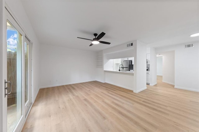 815 Lyle W Ave Unit A, Cleveland, TX 77327 - unfurnished living room featuring light wood-type flooring, a sink, ceiling fan, and baseboards