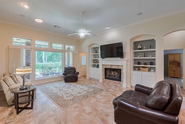 13719 Highland Cove Dr, Houston, TX 77070 - living area with built in shelves, crown molding, arched walkways, a fireplace, and a ceiling fan