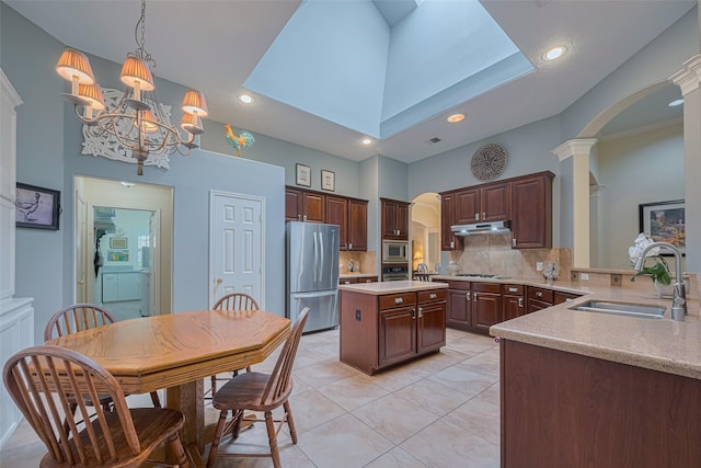 13719 Highland Cove Dr, Houston, TX 77070 - kitchen featuring appliances with stainless steel finishes, a sink, arched walkways, light countertops, and recessed lighting