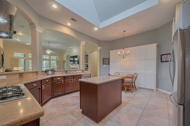 13719 Highland Cove Dr, Houston, TX 77070 - kitchen featuring decorative columns, stainless steel appliances, arched walkways, decorative light fixtures, and a kitchen island