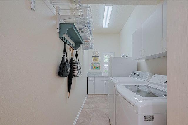 13719 Highland Cove Dr, Houston, TX 77070 - washroom featuring washing machine and dryer, cabinet space, light tile patterned floors, and baseboards