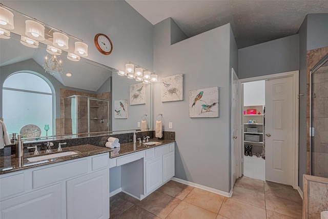 13719 Highland Cove Dr, Houston, TX 77070 - full bath with a stall shower, double vanity, vaulted ceiling, tile patterned floors, and a spacious closet