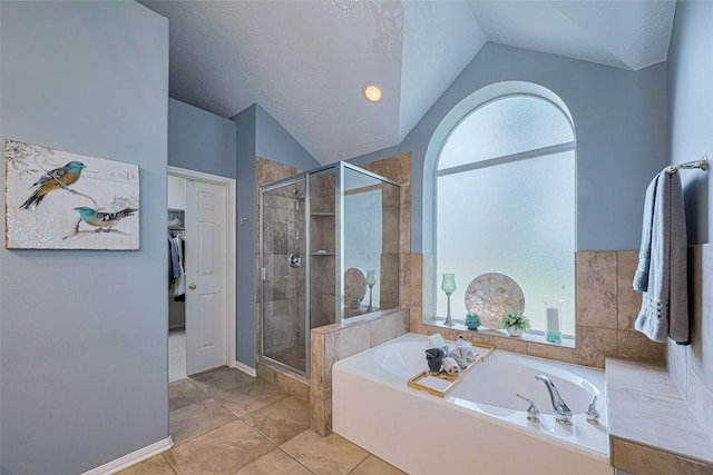 13719 Highland Cove Dr, Houston, TX 77070 - full bath with lofted ceiling, a bath, a stall shower, baseboards, and a walk in closet