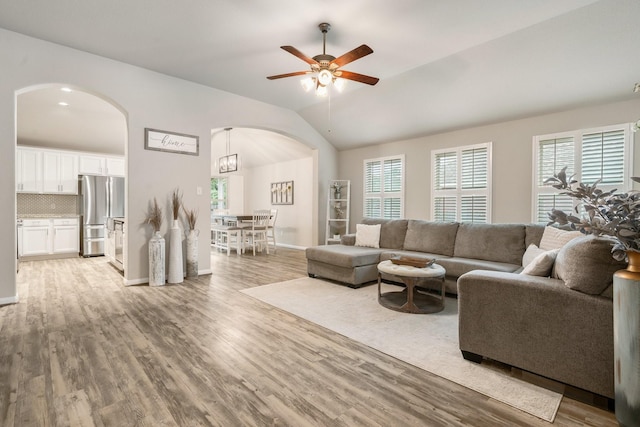 1724 Wandering Hills Rd, Conroe, TX 77304 - living room featuring arched walkways, healthy amount of natural light, a ceiling fan, and vaulted ceiling