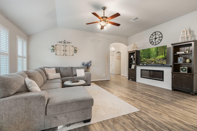 1724 Wandering Hills Rd, Conroe, TX 77304 - living room featuring arched walkways, wood finished floors, ceiling fan, lofted ceiling, and baseboards
