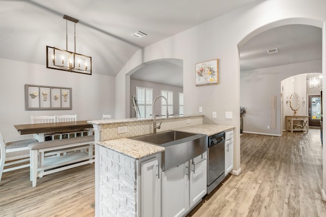 1724 Wandering Hills Rd, Conroe, TX 77304 - kitchen with a sink, stainless steel dishwasher, light stone counters, light wood-type flooring, and pendant lighting