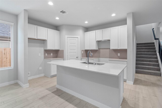 6630 Old Cypress Landing Ln, Humble, TX 77338 - kitchen with a sink, a center island with sink, white cabinets, tasteful backsplash, and recessed lighting