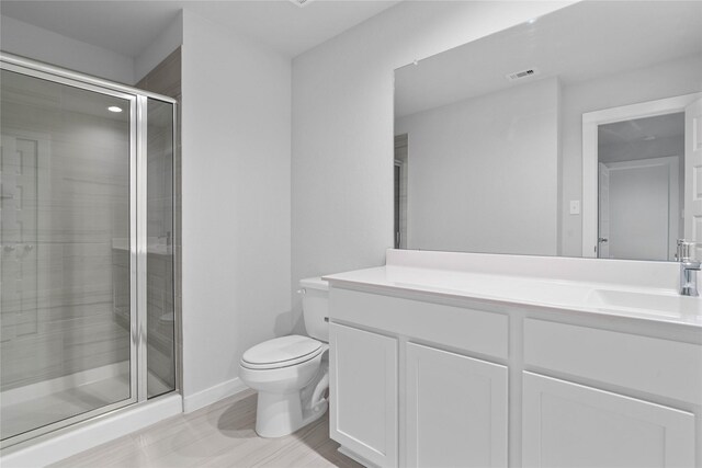 6630 Old Cypress Landing Ln, Humble, TX 77338 - bathroom featuring toilet, vanity, a stall shower, and baseboards