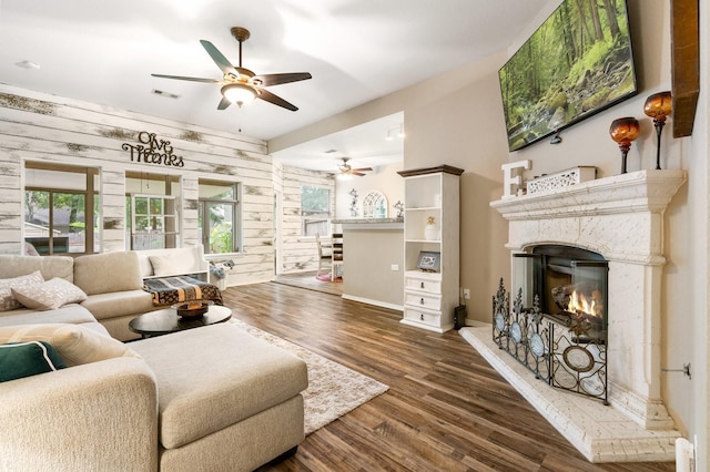 259 Adobe Ter S, Conroe, TX 77316 - living room featuring ceiling fan, a premium fireplace, wood finished floors, baseboards, and wood walls