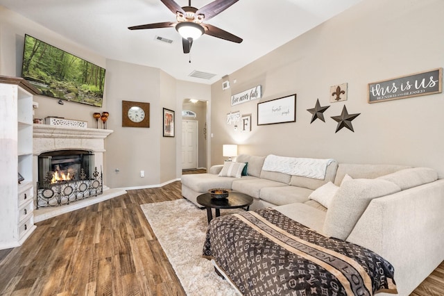 259 Adobe Ter S, Conroe, TX 77316 - living area featuring wood finished floors, a ceiling fan, a lit fireplace, and baseboards
