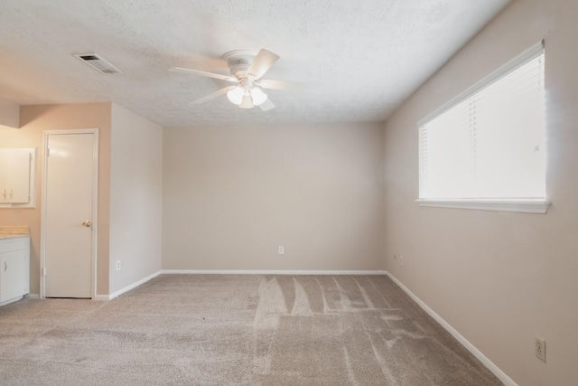12503 Tall Forest Dr, Cypress, TX 77429 - empty room with ceiling fan, light carpet, a textured ceiling, and baseboards