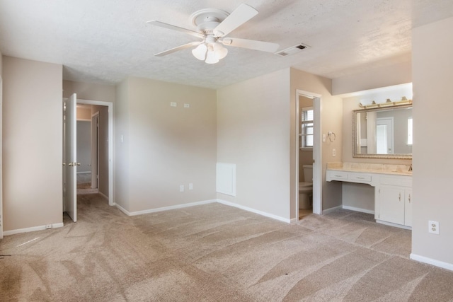 12503 Tall Forest Dr, Cypress, TX 77429 - unfurnished bedroom featuring light carpet, connected bathroom, a textured ceiling, baseboards, and an office area