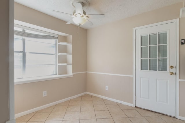 12503 Tall Forest Dr, Cypress, TX 77429 - unfurnished room featuring ceiling fan, a textured ceiling, light tile patterned floors, and baseboards