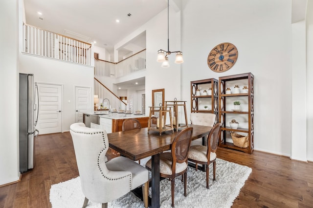 2608 Bisbee Rd, League City, TX 77573 - dining room with a towering ceiling, dark wood finished floors, and stairs