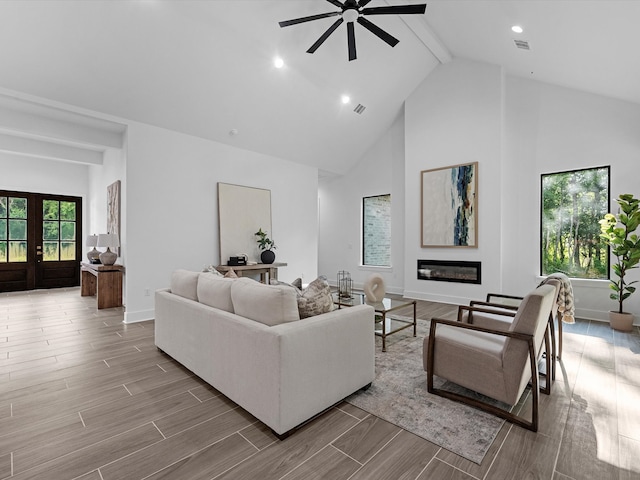 852 Rd 6609, Dayton, TX 77535 - living room with beam ceiling, high vaulted ceiling, ceiling fan, a glass covered fireplace, and wood finished floors