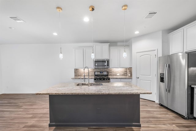 18202 Fehmarn Sound Cir, Houston, TX 77044 - kitchen with appliances with stainless steel finishes, a sink, backsplash, light wood finished floors, and light stone countertops