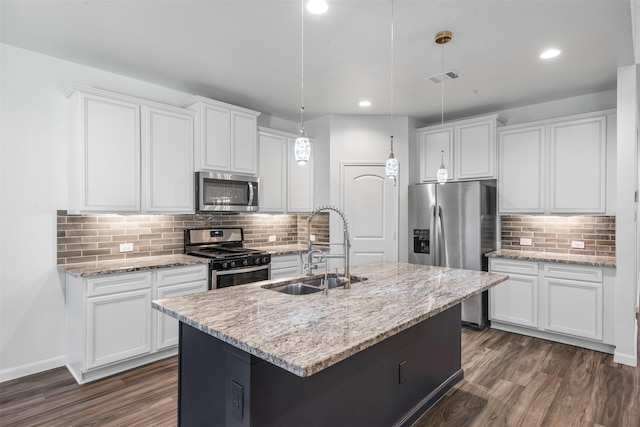 18202 Fehmarn Sound Cir, Houston, TX 77044 - kitchen featuring stainless steel appliances, a sink, backsplash, dark wood-style flooring, and a kitchen island with sink