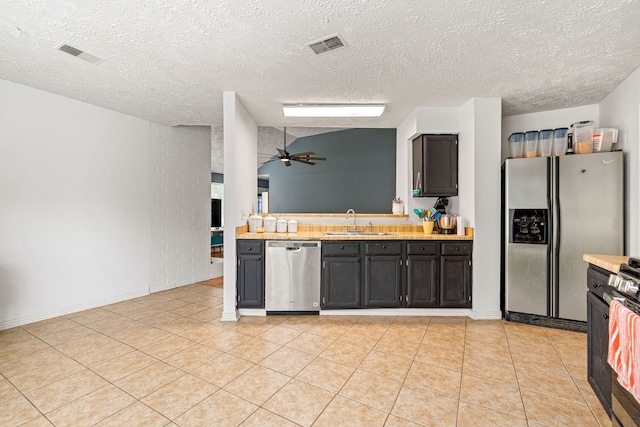327 Brompton Ct, Highlands, TX 77562 - kitchen featuring stainless steel appliances, a sink, ceiling fan, light countertops, and a textured ceiling