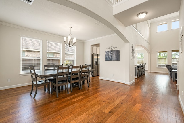 300 Bentside Pl, Clute, TX 77531 - dining space with arched walkways, a chandelier, dark wood-style flooring, baseboards, and ornamental molding